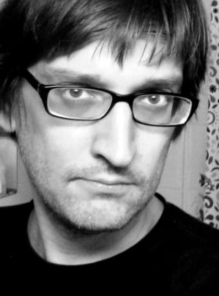 schwarzweiß-Portrait einer Person, ernster Blick, mit Brille